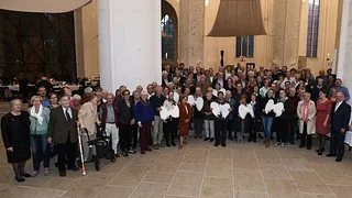 Symbolbild zur Unterseite für Besucher: zeigt Ehrenamtliche versammelt im Ostchor beim Engelsfest